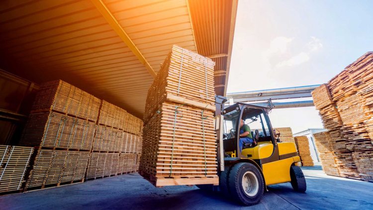 Yellow forklift moving two stacks of pallets