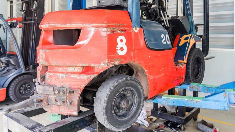 Red lift truck raised off the ground for forklift tire replacement